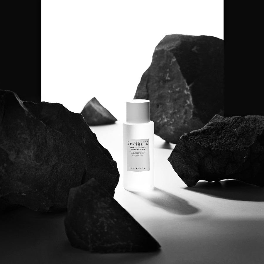 Flacon du toner SKIN1004 Centella Tone Brightening Boosting Toner entre des rochers noirs